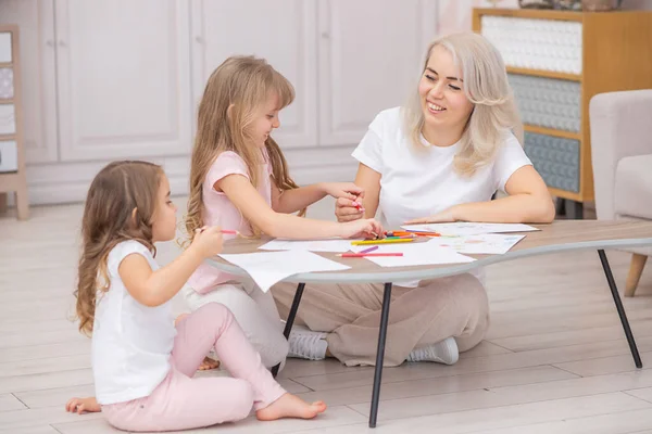 Kaukasische Mutter Und Kind Ziehen Zusammen Auf Dem Boden Wohnzimmer Stockfoto