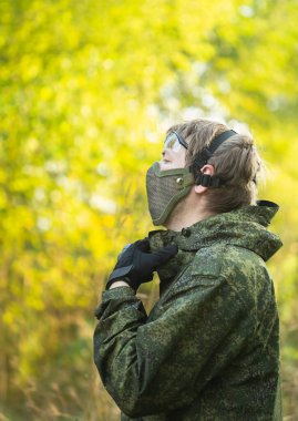 Tam teçhizatlı, güvenlik maskeli ve otomatik silahlı askerlerin portresi hava yumuşak top oynamaya hazırlanıyor.
