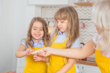 Kafkas anne ve iki kızı mutfakta birlikte yemek pişiriyor..