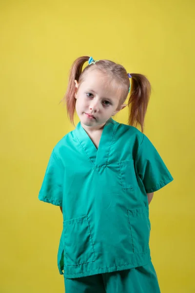 Retrato de niña caucásica vestida con abrigo verde de médicos — Foto de Stock