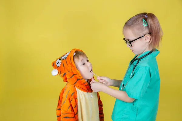Μικρά Καυκάσια Παιδιά Παίζουν Γιατρό Αγόρι Στολή Τίγρης Δείχνει Λαιμό — Φωτογραφία Αρχείου