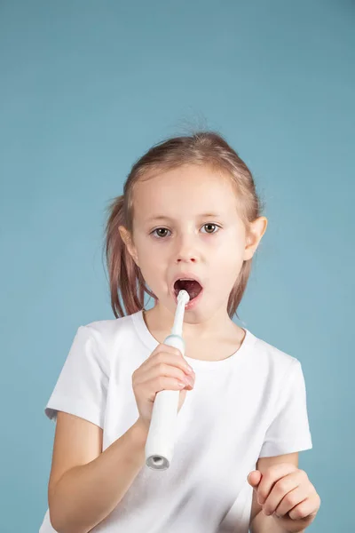 Adorabile piccolo bambino caucasico lavarsi i denti in piedi su sfondo blu — Foto Stock