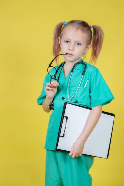 의사 옷을 입고 타블렛을 손에 들고 있는 심각 한 어린아이의 모습 — 스톡 사진