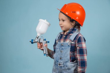 Kafkasya şapkalı, elektrikli tabancalı şirin beyaz çocuk inşaat ve onarım kavramı..