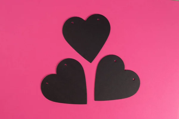 ピンクの背景にハート型の黒い段ボールリスト 愛のテキストのための場所 バレンタインデーのコンセプト — ストック写真