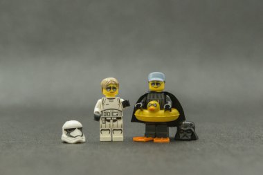 Bauru, Brezilya. 15 Eylül 2019. Star Wars lego figürü. Darth Vader ve dişi Stormtrooper kasksız, güneş gözlüklü ve tatilde. Darth Vader eğlence için sarı ördek şamandırası kullanıyor..