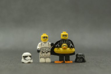 Bauru, Brezilya. 15 Eylül 2019. Star Wars lego figürü. Darth Vader ve dişi Stormtrooper kasksız, güneş gözlüklü ve tatilde. Darth Vader eğlence için sarı ördek şamandırası kullanıyor..