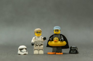 Bauru, Brezilya. 15 Eylül 2019. Star Wars lego figürü. Darth Vader ve dişi Stormtrooper kasksız, güneş gözlüklü ve tatilde. Darth Vader eğlence için sarı ördek şamandırası kullanıyor..
