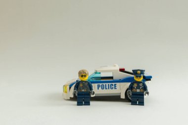 Florianpolis, Brezilya, 27 Mart 2020: Polis memurları beyaz arka planda devriye arabasının önünde minimuma iniyorlar. Lego minyatürleri Lego Grubu tarafından üretiliyor..