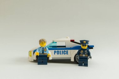 Florianpolis, Brezilya, 27 Mart 2020: Polis memurları beyaz arka planda devriye arabasının önünde minimuma iniyorlar. Lego minyatürleri Lego Grubu tarafından üretiliyor..