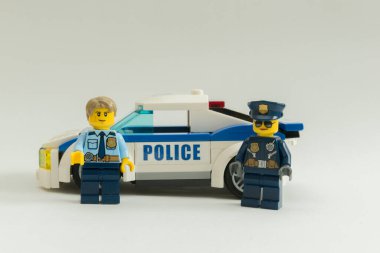 Florianpolis, Brezilya, 27 Mart 2020: Polis memurları beyaz arka planda devriye arabasının önünde minimuma iniyorlar. Lego minyatürleri Lego Grubu tarafından üretiliyor..
