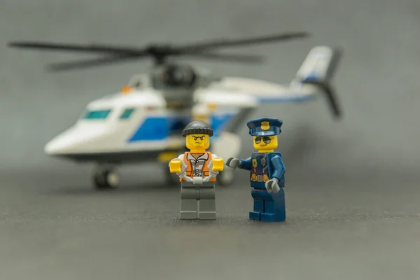 Bauru, Brezilya. 15 Eylül 2019. Polis eskortuyla kelepçelenmiş küçük hırsız figürü. Polis memurları tehlikeli bir suç taşıyorlar. Lego minyatürleri Lego Grubu tarafından üretiliyor..