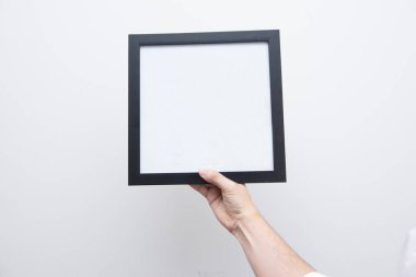 Empty photo frame in man hands. Isolated on white background. An empty frame with a white background. Copy space.