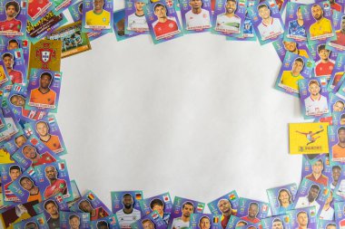 Bauru, Brezilya - 09.12.22: Panini Albüm Fifa Dünya Kupası 2022 - Katar 2022. Dünya kupası kartları beyaz masaya dağıtıldı. Gençler kart topluyor. Metin alanı ve seçici odaklanma. Kare kart