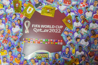 Bauru, Brezilya - 09.12.22: Panini Albüm Fifa Dünya Kupası 2022 - Masadaki Katar 'ın üst görüntüsü ve dünya takımları kupasındaki oyuncuların kolleksiyonlu etiketleriyle kaplı - FIFA. Seçici odak.