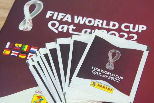 Bauru, Brezilya - 12. SEP 2022: Panini Albümü Fifa Dünya Kupası 2022 - Katar. Masadaki Panini albümündeki çıkartmaları kapat. Dünyanın dört bir yanındaki yetişkinlerden ve çocuklardan Hobbie. Seçici odak.