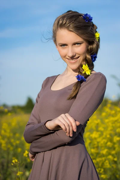 Joven hermosa chica sonriente con flores en el pelo, retrato de media longitud al aire libre —  Fotos de Stock