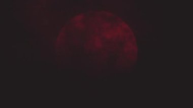 Kusursuz kıvrımlı koyu kırmızı ay ve bulutlar. Canlandırılmış arkaplan.