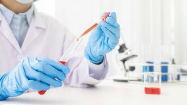 Bilim adamı, ilaç laboratuarındaki bir deney tüpünün içine bir numune bırakıyor. Yenilik Konsepti.