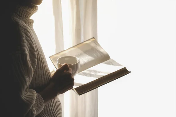 Azjatka Trzymająca Filiżankę Kawy Czytająca Książkę Przy Oknie Wstaniu Rano — Zdjęcie stockowe