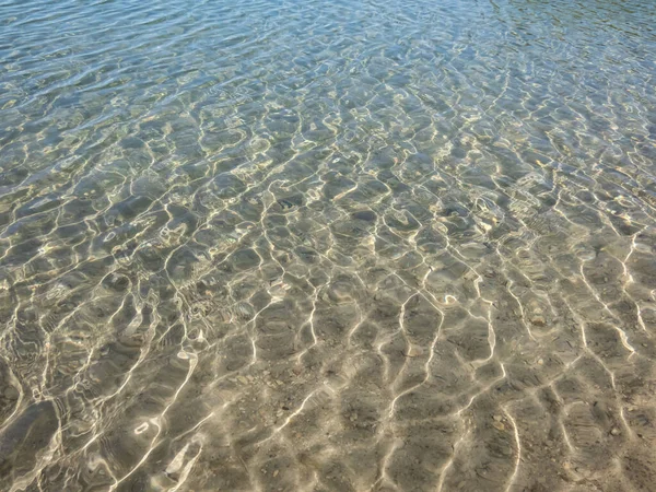 水の動きに太陽の明るい反射と美しい 透明なライトブルーとターコイズ透明水のテクスチャ 水の背景 — ストック写真