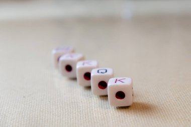 Ön planda aslar olan beyaz arkaplanda beş zarlı satır