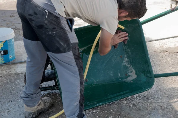 Genç işçi bir günlük çalışmadan sonra forklift temizliyor..