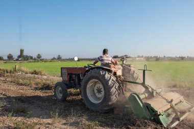 Çiftçinin yeni bir hasat başlatmak için toprağı işlemesi