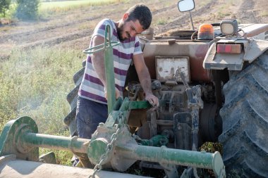 Genç çiftçi meyve bahçesinin ekimine başlamak için çiftlik aletlerini hazırlıyor..