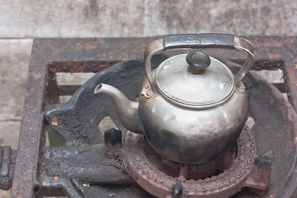 Старый чайник на ржавой газовой плите — стоковое фото