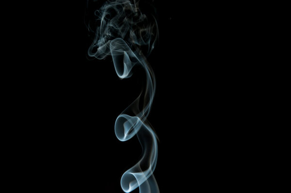 White cigarette smoke on black background, forming abstract figures