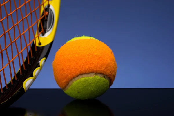 Bola de tênis para crianças com raquete de tênis em fundo azul — Fotografia de Stock
