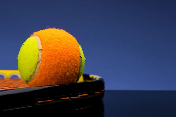 Tennisbal voor kinderen met een tennisracket op blauwe achtergrond — Stockfoto