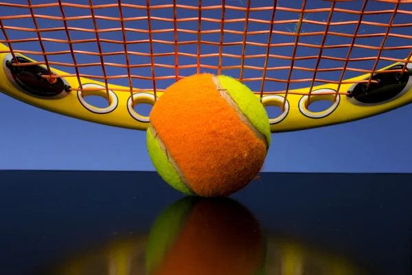 파란색 배경에 테니스 라켓과 어린이 위한 테니스 공 — 스톡 사진
