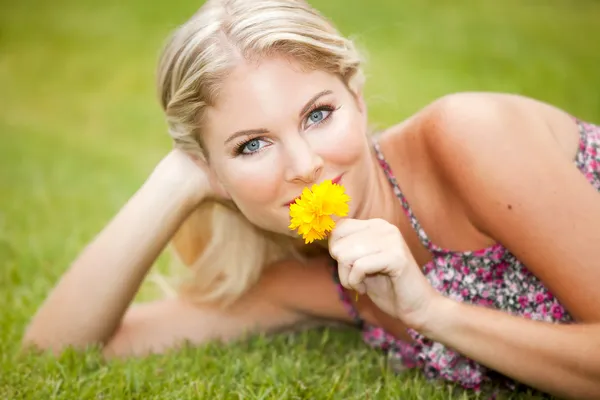 Kvinna på gräs med blomma — Stockfoto