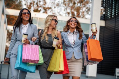 Alışveriş çantasıyla gülümseyen iş kadınlarının portresi. İnsanlar, moda ve alışveriş konsepti..
