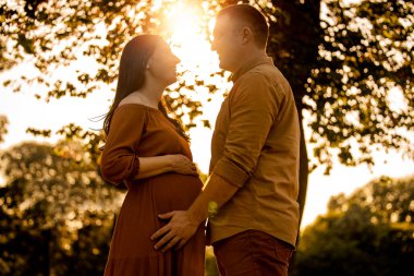 Romantik hamile çift yaz gününün tadını çıkarıyor. Aşk, insanlar, mutluluk ve yaşam tarzı kavramı..