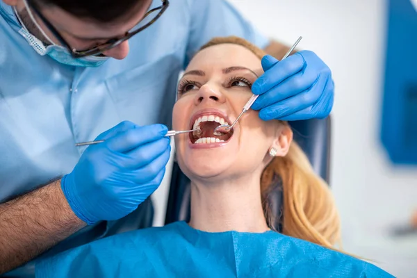 在牙科诊所检查病人牙齿的牙科医生 — 图库照片