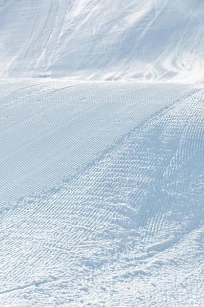 Alpina skidor pisten med skid- och snowboard spår — Stockfoto