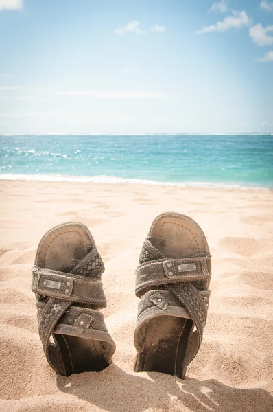 Sandalias en la arena de una playa tropical — Foto de Stock