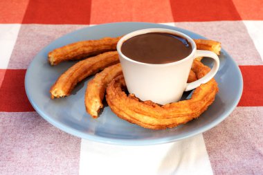 Endülüs, İspanya 'da fincanı, kahvaltıyı veya aperatifi kaplayan bir fincan çikolata ve churro ile tabak..