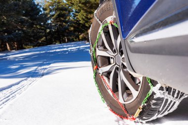 Car wheel with chains and on the snow.