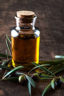 Dallarında zeytin yağının yanında ekstra saf zeytin yağı olan bir şişe..