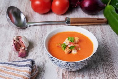 Domates, sarımsak, biber ve soğana dayalı soğuk çorba, tipik Endülüs çorbası. Beyaz ahşap arka planda.