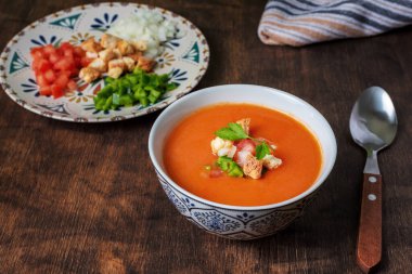 Gazpacho, domates, sarımsak, biber ve soğana dayalı tipik Endülüs soğuk çorbası. Koyu bir ahşap arka planda.