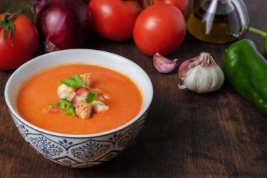 Gazpacho, domates, sarımsak, biber ve soğana dayalı tipik Endülüs soğuk çorbası. Koyu bir ahşap arka planda.
