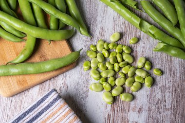Beyaz ahşap bir masada geniş fasulyeler, üst manzara..