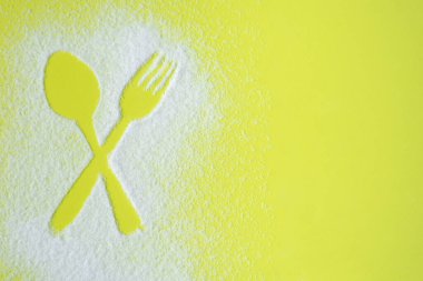 Çapraz kaşık ve çatal figürü yeşil zemin üzerinde şeker rahatlatıcı oluşturuldu. 