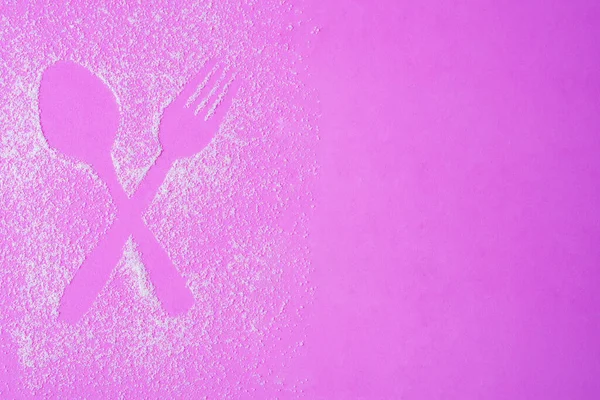 Çapraz kaşık ve çatal figürü pembe arka planda şeker rahatlatıcı oluşturuldu. 