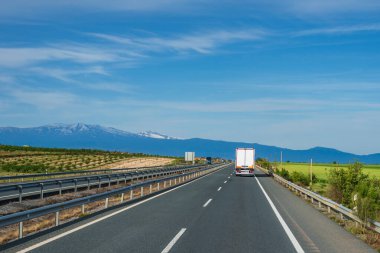 Arka planda Sierra Nevada ile otoyol boyunca giden buzdolabı kamyonu..